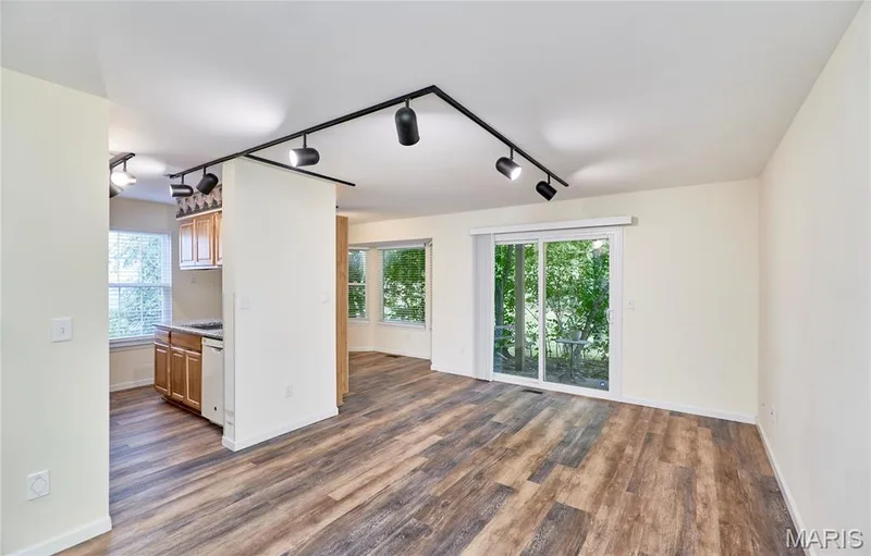 Wood-finish flooring throughout, track lighting, light wood cabinetry, and sliding glass door — 146 Old Buggy Court #A, St Charles, MO 63304