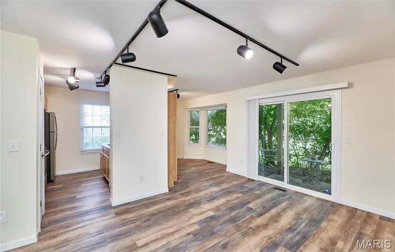 Wood-finish flooring throughout, track lighting, sliding glass door, and multiple windows — 146 Old Buggy Court #A, St Charles, MO 63304