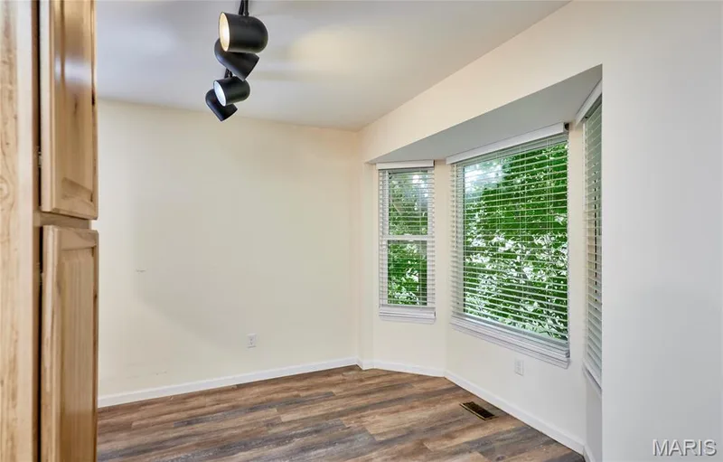 Wood-finish flooring, bay window, track lighting, and built-in wood cabinetry — 146 Old Buggy Court #A, St Charles, MO 63304
