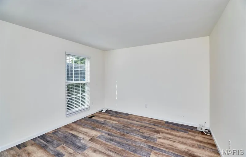 Wood-finish flooring, white walls, two windows with blinds — 146 Old Buggy Court #A, St Charles, MO 63304