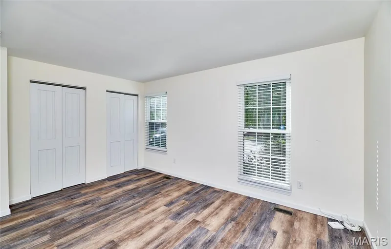 Wood-finish flooring, white walls, and two windows with blinds — 146 Old Buggy Court #A, St Charles, MO 63304