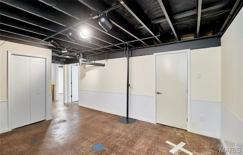 Exposed beam ceiling with track lighting, beadboard wainscoting, bi-fold closet doors, and painted concrete flooring — 146 Old Buggy Court #A, St Charles, MO 63304
