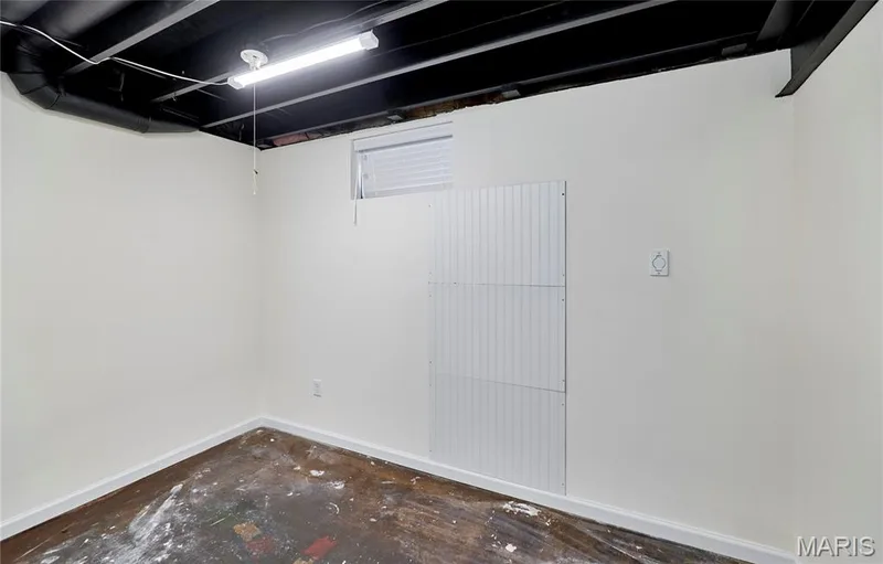 Painted exposed ceiling joists with utility pipes, fluorescent lighting, white painted walls, and a small window with blinds — 146 Old Buggy Court #A, St Charles, MO 63304