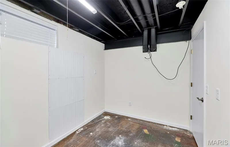 Painted exposed ceiling joists with utility pipes, fluorescent lighting, white painted walls, and a small window with blinds — 146 Old Buggy Court #A, St Charles, MO 63304