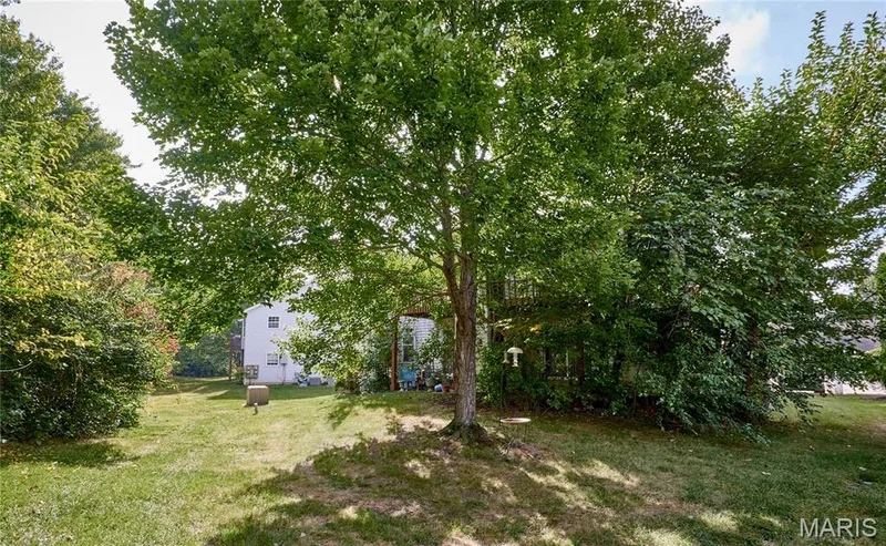 Manicured lawn with mature trees and established perimeter landscaping — 146 Old Buggy Court #A, St Charles, MO 63304