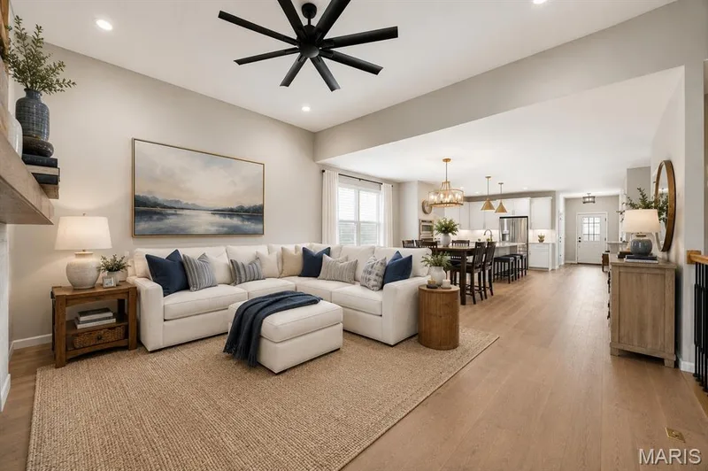 Large great room with 11' ceilings, electric gas fireplace, warm engineered wood flooring — 204 Randlin Drive, Lake St. Louis, MO 63367