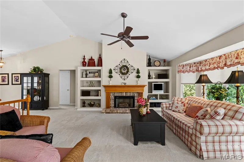 View of bright great room showing fireplace, bay and built-in bookcases — 8 Autumn Grove Court, O'Fallon, MO 63366