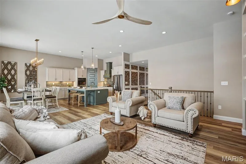 Open-concept living area featuring wood-finish flooring, recessed lighting, and a neutral color palette — 312 Summer Glen Lane, St Charles, MO 63301