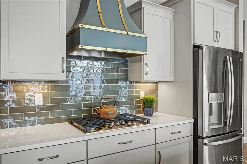 Custom teal and brass range hood above a gas cooktop — 312 Summer Glen Lane, St Charles, MO 63301