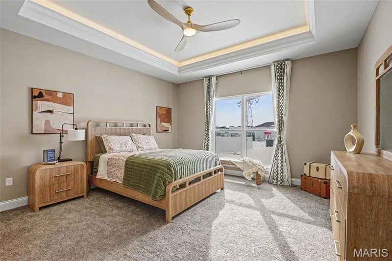Spacious bedroom featuring a tray ceiling with recessed lighting, a ceiling fan, and carpeted flooring — 312 Summer Glen Lane, St Charles, MO 63301