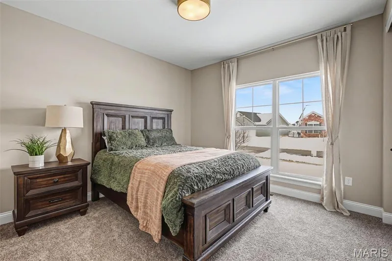 Carpeted bedroom featuring neutral wall tones and a double-pane window with white trim — 312 Summer Glen Lane, St Charles, MO 63301