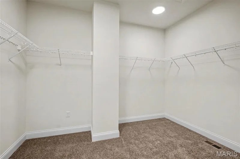 Spacious walk-in closet featuring light-colored walls, wire shelving, recessed lighting, and brown carpet flooring — 312 Summer Glen Lane, St Charles, MO 63301