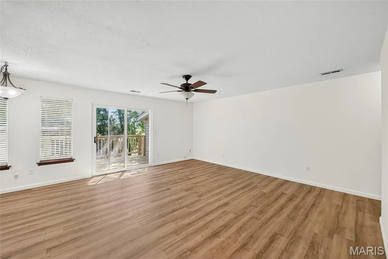 Great Room with Luxury Vinyl Plank Flooring and Sliding Glass Door opening to Deck — 1044 Sugar Creek Court #5, St Peters, MO 63376
