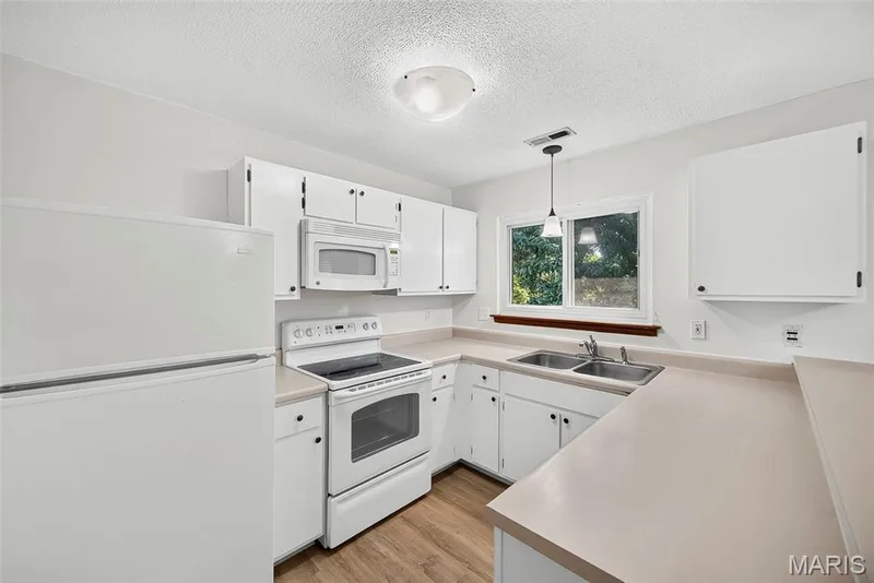 Kitchen with Laminate Countertops, Smooth Top Electric Range, Microwave, Dishwasher and Refrigerator — 1044 Sugar Creek Court #5, St Peters, MO 63376