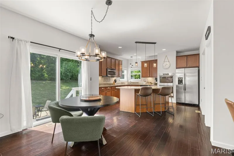 Spacious kitchen featuring rich wood cabinetry, stainless steel appliances, and a central island with bar seating — 921 Molloy Drive, O'Fallon, MO 63366