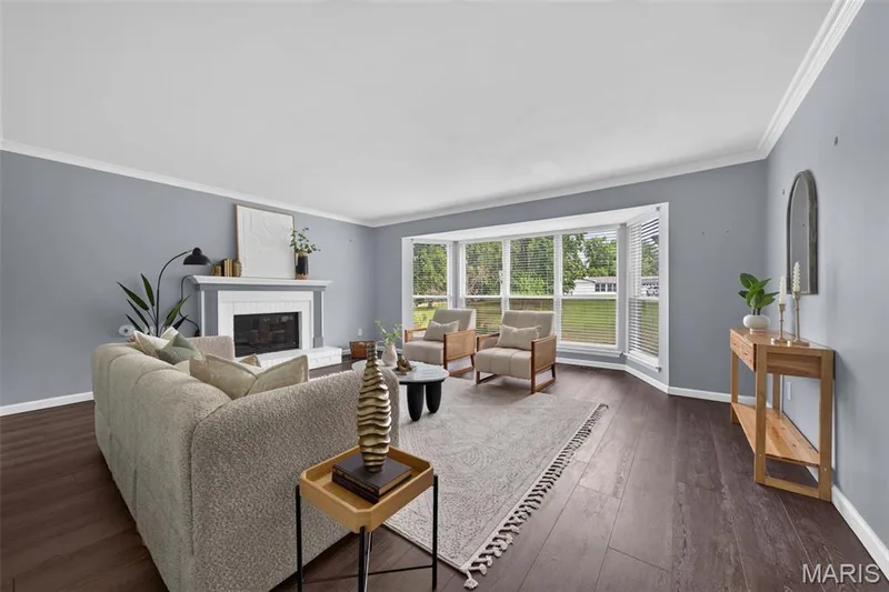 Bright and spacious living room with bay windows, crown molding and a gas fireplace. — 1016 Lafayette Place, Lake St. Louis, MO 63367