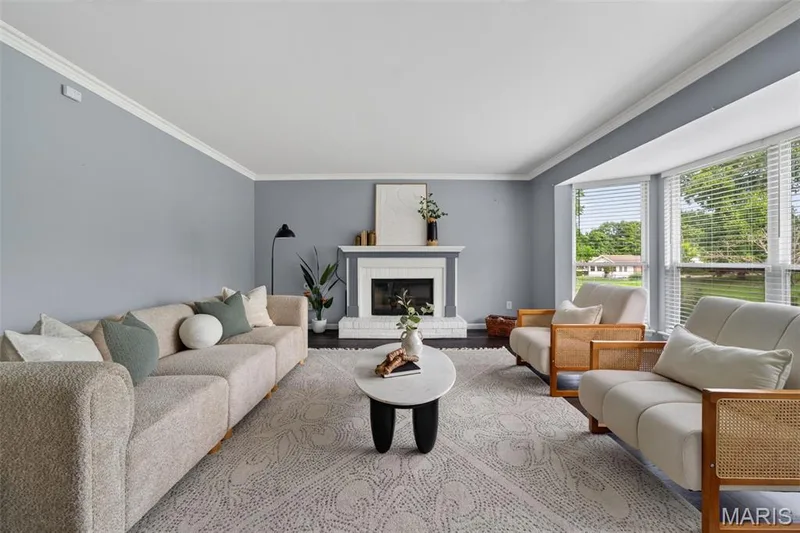 Bright and spacious living room with bay windows, crown molding and a gas fireplace. — 1016 Lafayette Place, Lake St. Louis, MO 63367