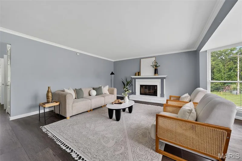 Bright and spacious living room with bay windows, crown molding and a gas fireplace. — 1016 Lafayette Place, Lake St. Louis, MO 63367