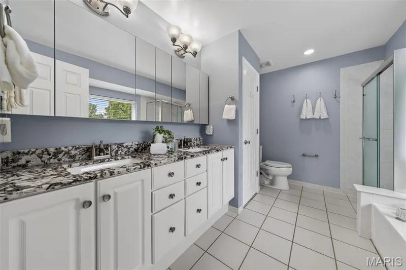 Large primary bathroom with soaking tub, separate shower and double vanity with granite countertops. — 1016 Lafayette Place, Lake St. Louis, MO 63367
