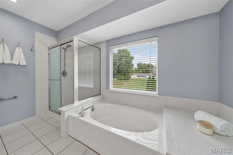Large primary bathroom with soaking tub, separate shower and double vanity with granite countertops. — 1016 Lafayette Place, Lake St. Louis, MO 63367
