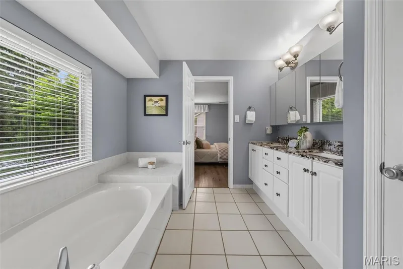 Large primary bathroom with soaking tub, separate shower and double vanity with granite countertops. — 1016 Lafayette Place, Lake St. Louis, MO 63367