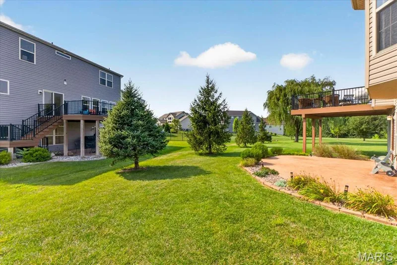 Manicured backyard with pines — 713 Bellingrath Gardens Court, Wentzville, MO 63385