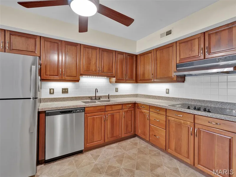 The kitchen with stainless steel appliances and a lighted ceiling fan. — 208 Ambridge Court #206, Chesterfield, MO 63017
