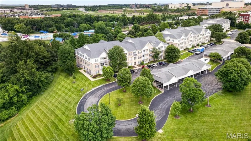 Multi-story residential buildings featuring stone and siding exteriors, gabled roofs, and multiple balconies — 5 Monarch Trace Court #108, Chesterfield, MO 63017