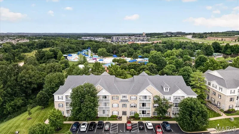 Multi-story residential building with light-toned brick and siding facades, featuring balconies on multiple levels — 5 Monarch Trace Court #108, Chesterfield, MO 63017