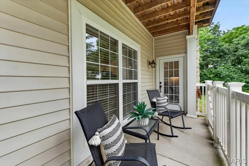 Exterior balcony featuring a concrete surface, white spindle railing, and a wood-paneled ceiling — 5 Monarch Trace Court #108, Chesterfield, MO 63017