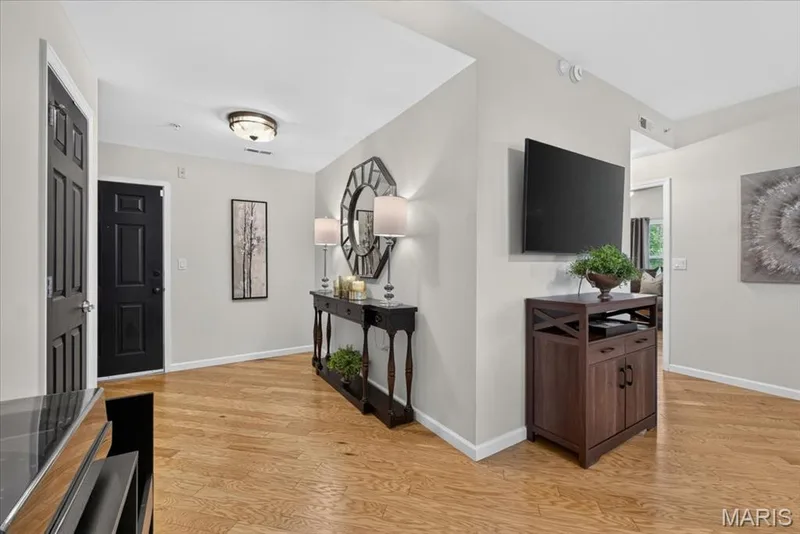 Wood-finish flooring extending throughout the entry area — 5 Monarch Trace Court #108, Chesterfield, MO 63017