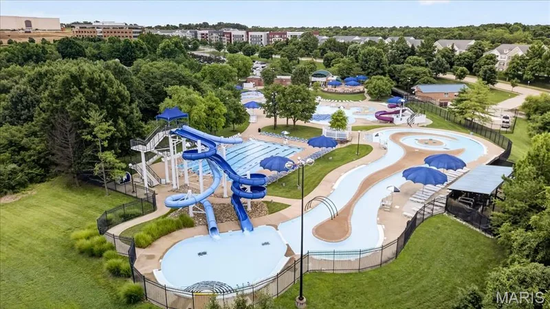 Expansive aquatic center featuring multiple pools, a serpentine water slide complex, a lazy river, and shaded lounge areas — 5 Monarch Trace Court #108, Chesterfield, MO 63017