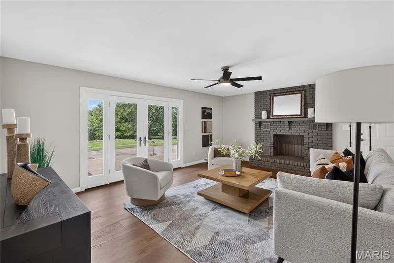 Living area featuring wood-finish flooring, a contemporary ceiling fan, and light-toned walls — 33 Timber Ridge Drive, Marthasville, MO 63357
