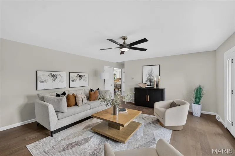 Spacious living area featuring wood-finish flooring, light-toned walls, and a ceiling fan with integrated lighting — 33 Timber Ridge Drive, Marthasville, MO 63357