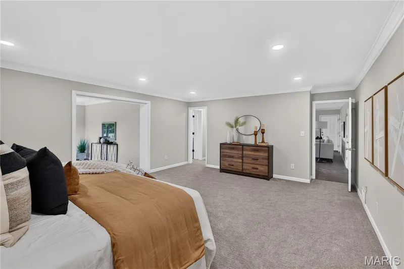 Spacious interior room featuring light gray wall paint, crown molding, recessed lighting, and gray carpeting — 33 Timber Ridge Drive, Marthasville, MO 63357
