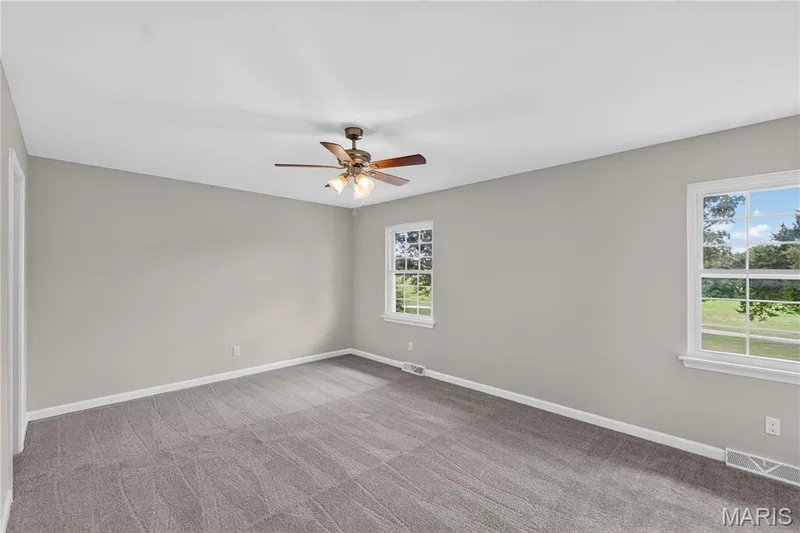 Spacious room featuring neutral grey wall paint, plush grey carpet flooring, and white trim — 33 Timber Ridge Drive, Marthasville, MO 63357