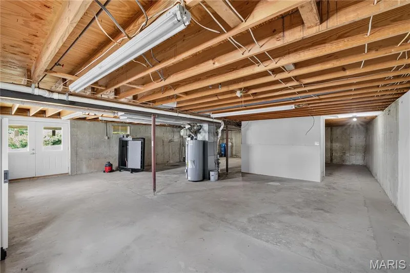 Expansive unfinished basement featuring concrete flooring and exposed wood ceiling joists — 33 Timber Ridge Drive, Marthasville, MO 63357