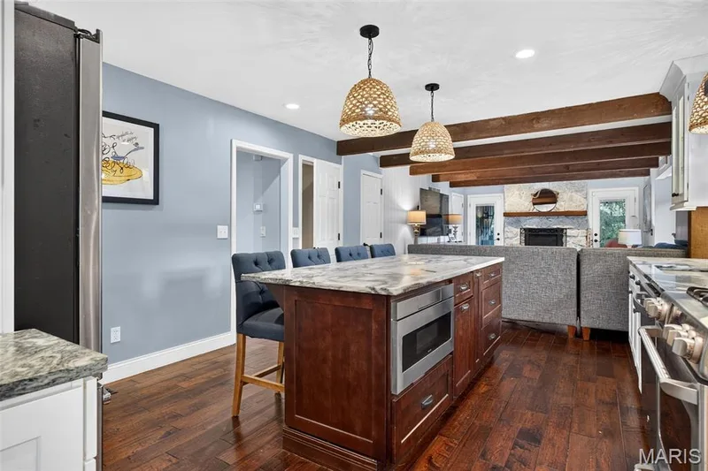 Kitchen island with a stone countertop and built-in microwave drawer — 4 Chantilly Court, Lake St. Louis, MO 63367