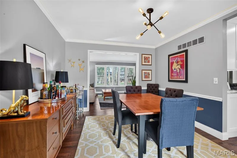 Hardwood-finish flooring extends throughout this dining area, featuring a decorative ceiling light fixture — 4 Chantilly Court, Lake St. Louis, MO 63367