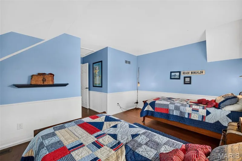 Large walk in closet, Interior room featuring wood-finish flooring, two-tone walls with white wainscoting, and a wall-mounted floating shelf — 4 Chantilly Court, Lake St. Louis, MO 63367