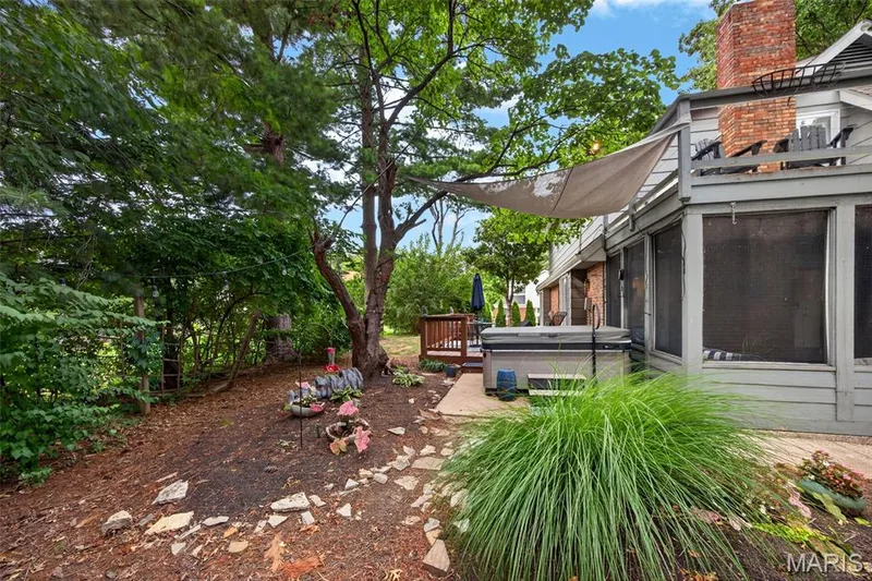 Outdoor living space featuring a hot tub, screened porch, and an upper-level deck — 4 Chantilly Court, Lake St. Louis, MO 63367