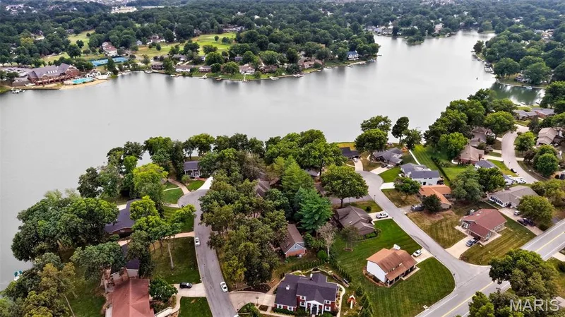 Expansive residential area featuring established homes, mature trees, paved streets, and a prominent lake — 4 Chantilly Court, Lake St. Louis, MO 63367