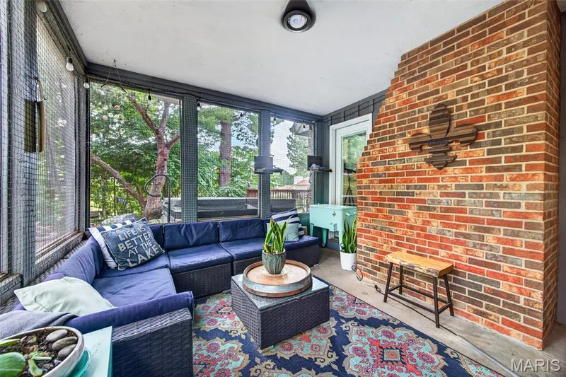 Screened-in porch featuring a brick accent wall, a white ceiling, and large window screens — 4 Chantilly Court, Lake St. Louis, MO 63367