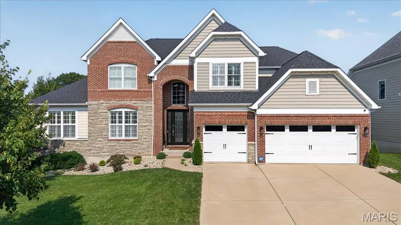 Two-story residence featuring a brick and stone facade with horizontal siding accents — 302 Oak Stand Court, Chesterfield, MO 63005