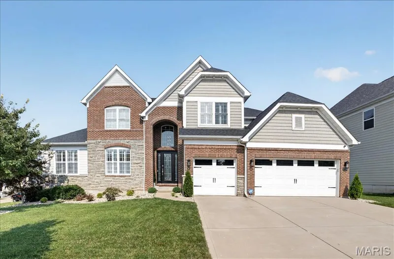 Two-story residence featuring a brick and stone facade with siding accents — 302 Oak Stand Court, Chesterfield, MO 63005