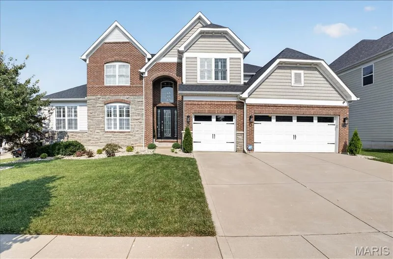 Two-story residence featuring a brick and stone facade with siding accents — 302 Oak Stand Court, Chesterfield, MO 63005