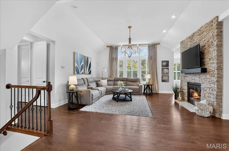 Spacious living area featuring wood-finish flooring, a vaulted ceiling, and recessed lighting — 302 Oak Stand Court, Chesterfield, MO 63005