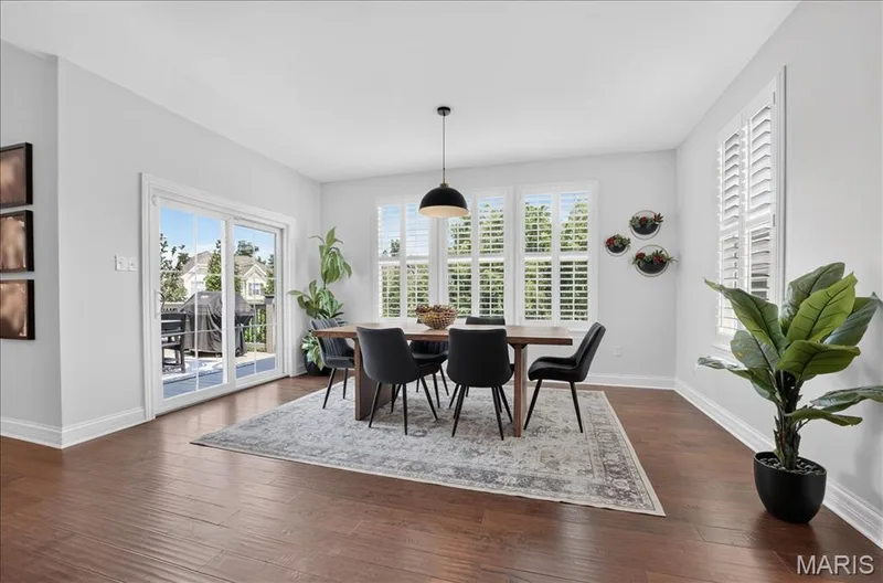 Dining area featuring wood-finish flooring, white baseboards, and light gray wall paint — 302 Oak Stand Court, Chesterfield, MO 63005