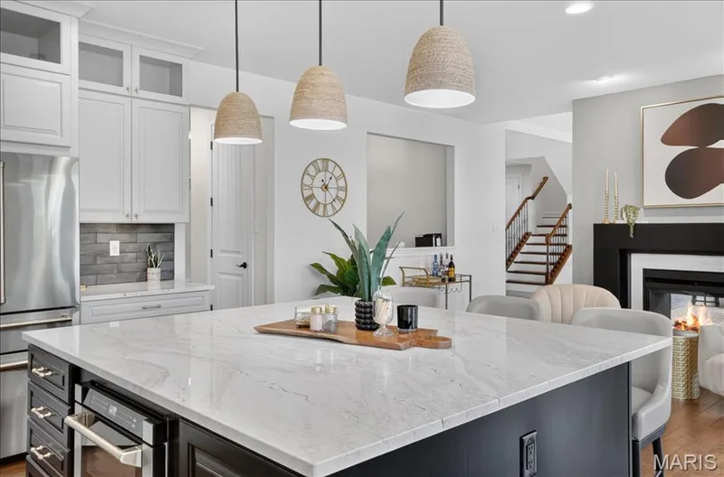 Spacious kitchen island featuring a light-toned countertop with integrated oven and ample seating — 302 Oak Stand Court, Chesterfield, MO 63005
