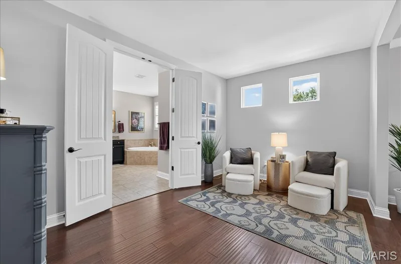 Expansive room featuring rich wood-finish flooring, light gray walls, and white trim — 302 Oak Stand Court, Chesterfield, MO 63005